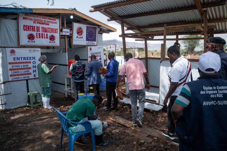 Officials from the Ituri Provincial Health Division (DPS), humanitarian partners and health sector representatives undergo temperature screening and handwashing before entering the Ebola treatment centre of Rwampara General Reference Hospital in Rwampara, Ituri Province, Democratic Republic of Congo, on June 12, 2026. (Photo by Jospin Mwisha / AFP)